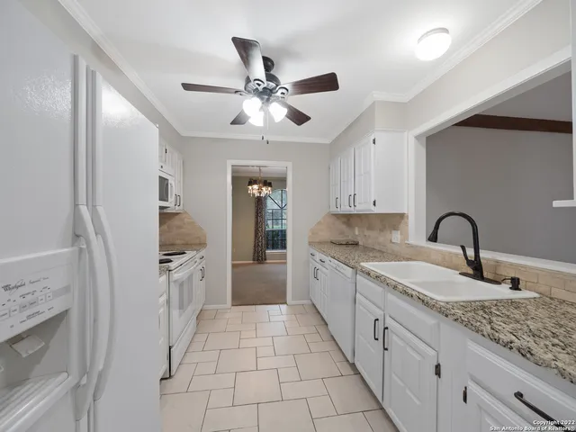 a kitchen with granite countertop a sink stainless steel appliances and cabinets
