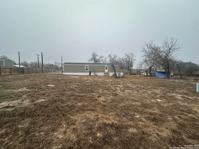 a view of dirt yard with a large tree
