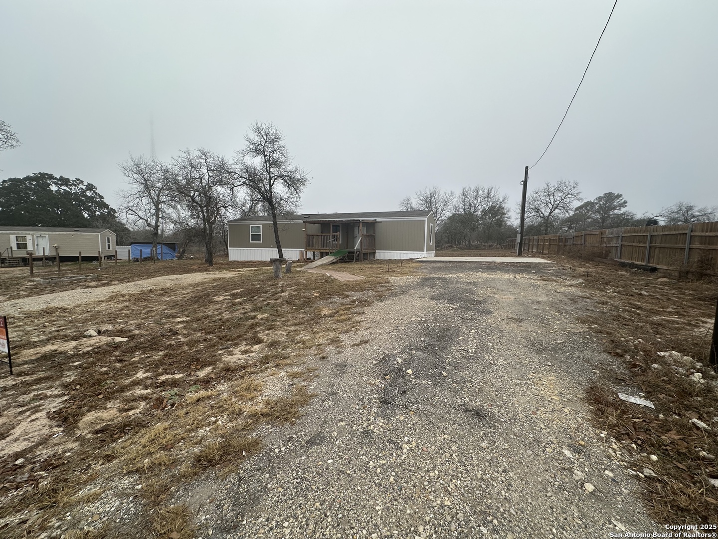 101 Villa Ridge Drive, Unit 6 Poteet, TX 78065 - Photo 2 of 14 a view of dirt yard with a large tree