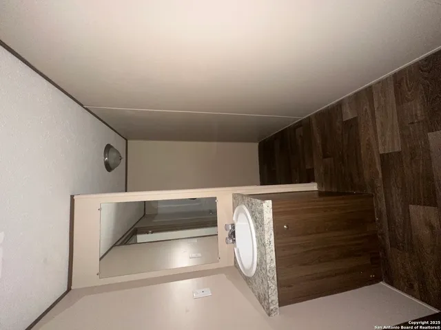 a bathroom with a granite countertop sink mirror vanity and toilet