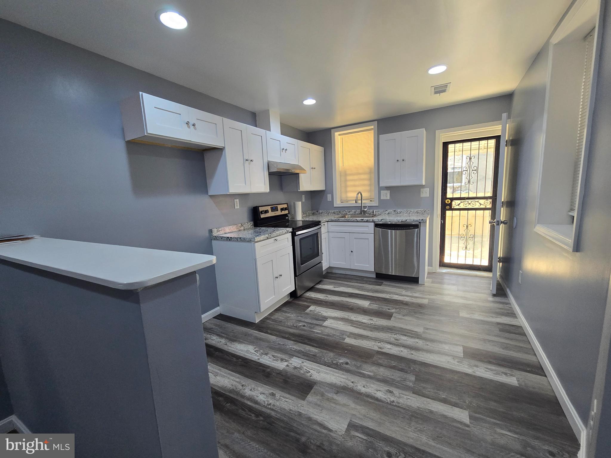 1926 North Payson Street Baltimore, MD 21217 - Photo 8 of 29 a large white kitchen with stainless steel appliances granite countertop a stove a sink dishwasher and a refrigerator