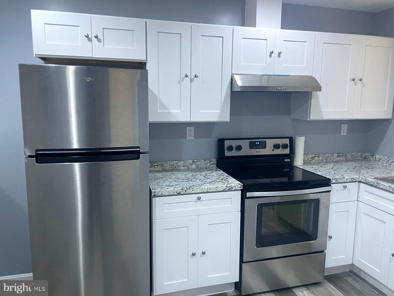 1926 North Payson Street Baltimore, MD 21217 - Photo 10 of 29 a kitchen with granite countertop white cabinets and stainless steel appliances