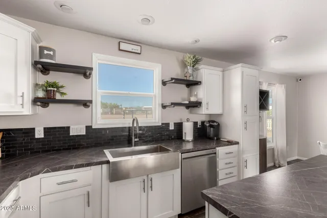 a kitchen with white cabinets and black appliances