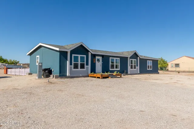 a backyard of a house with barbeque oven table and chairs