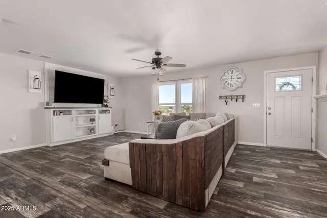 a living room with furniture and a dining table with wooden floor