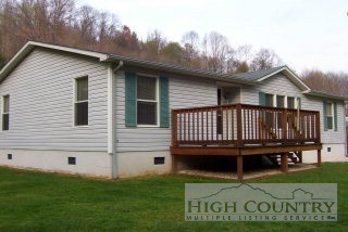 386 West Calhoun Road Lansing, NC 28643 - Photo 1 of 1 a view of a house with a small yard and wooden fence