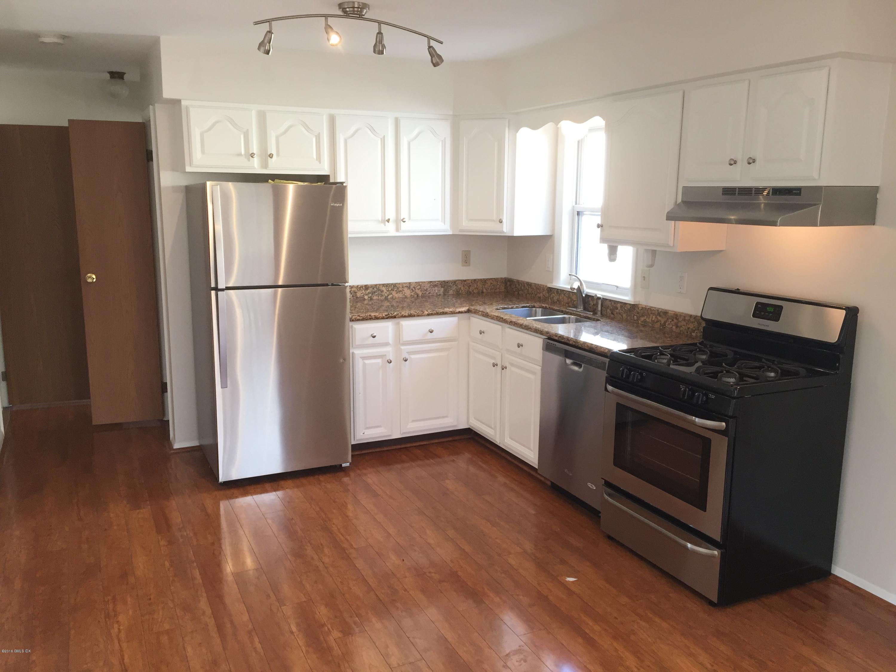 6 Booth Court Greenwich, CT 06830 - Photo 4 of 11 a kitchen with a refrigerator stove and wooden cabinets