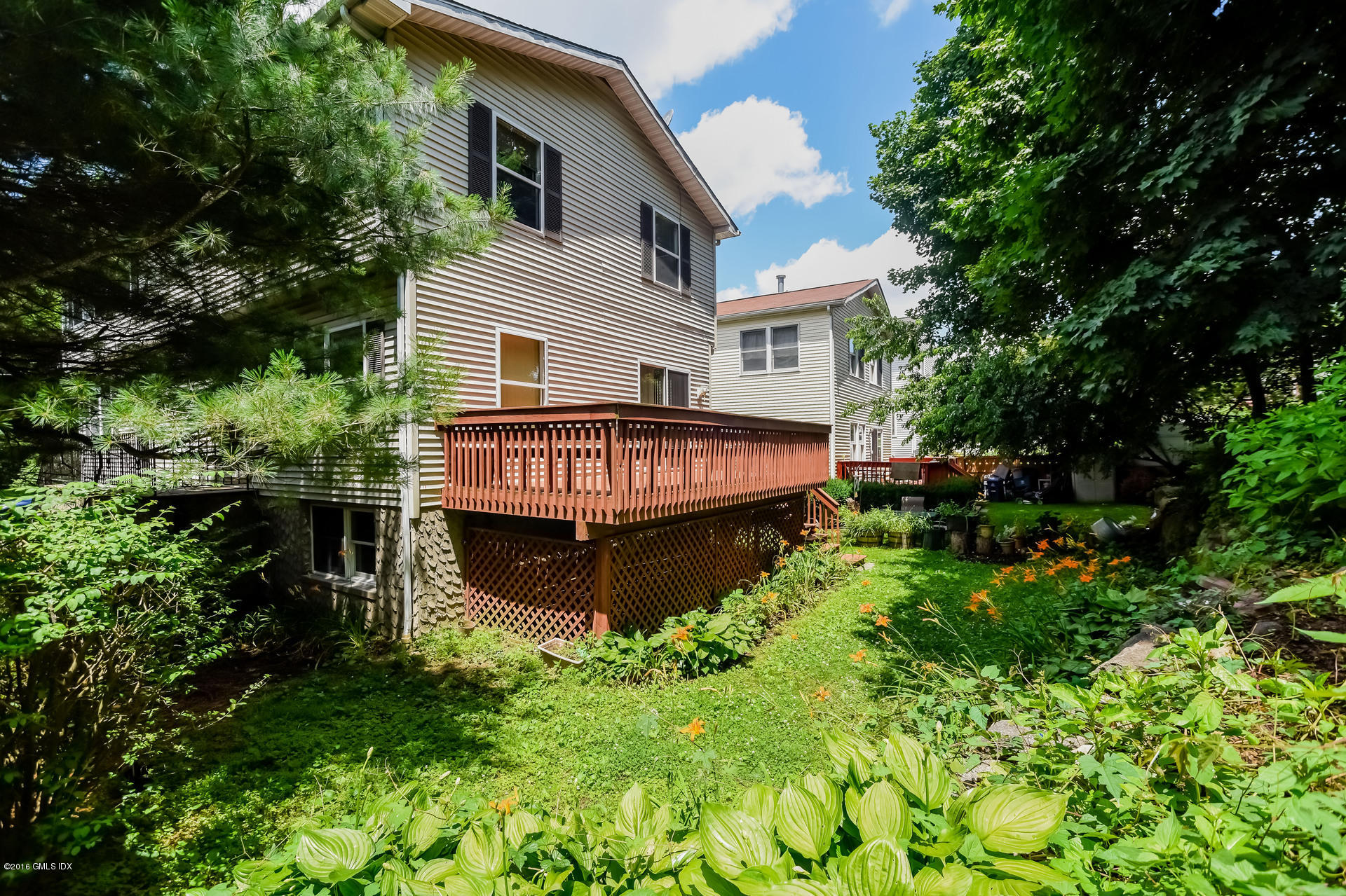 6 Booth Court Greenwich, CT 06830 - Photo 10 of 11 a view of a house with brick walls and a yard with plants