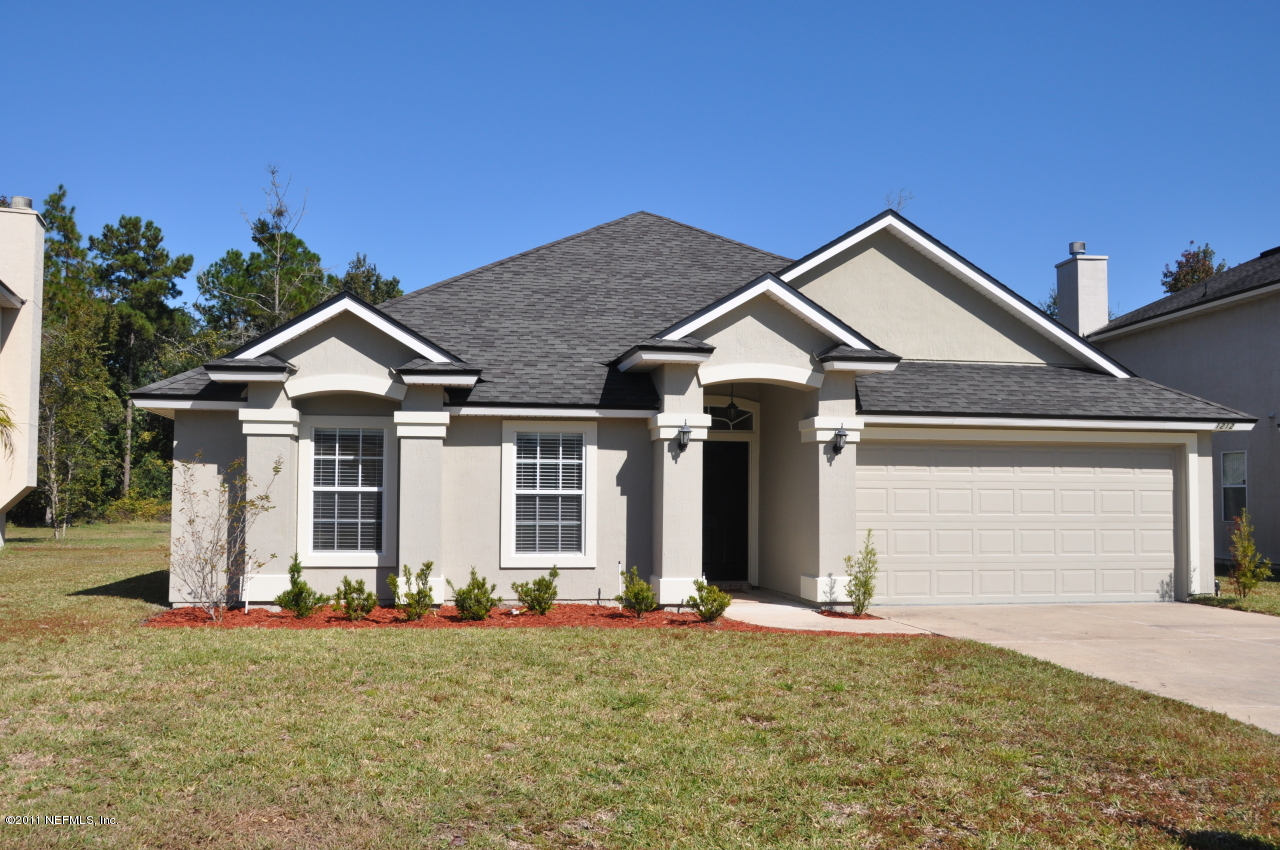 1212 Ribbon Road St. Johns, FL 32259 - Photo 1 of 10 a front view of a house with a yard and garage