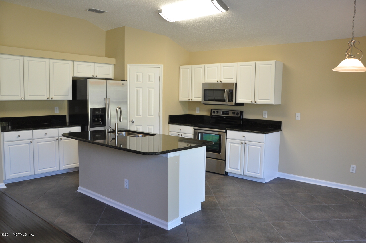 1212 Ribbon Road St. Johns, FL 32259 - Photo 2 of 10 a kitchen with stainless steel appliances a sink stove and refrigerator