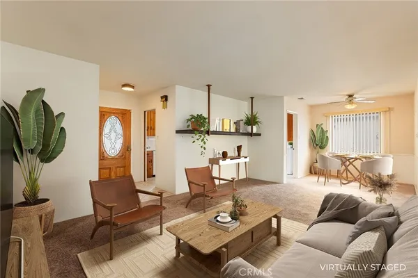 a living room with furniture a large window and gym equipment