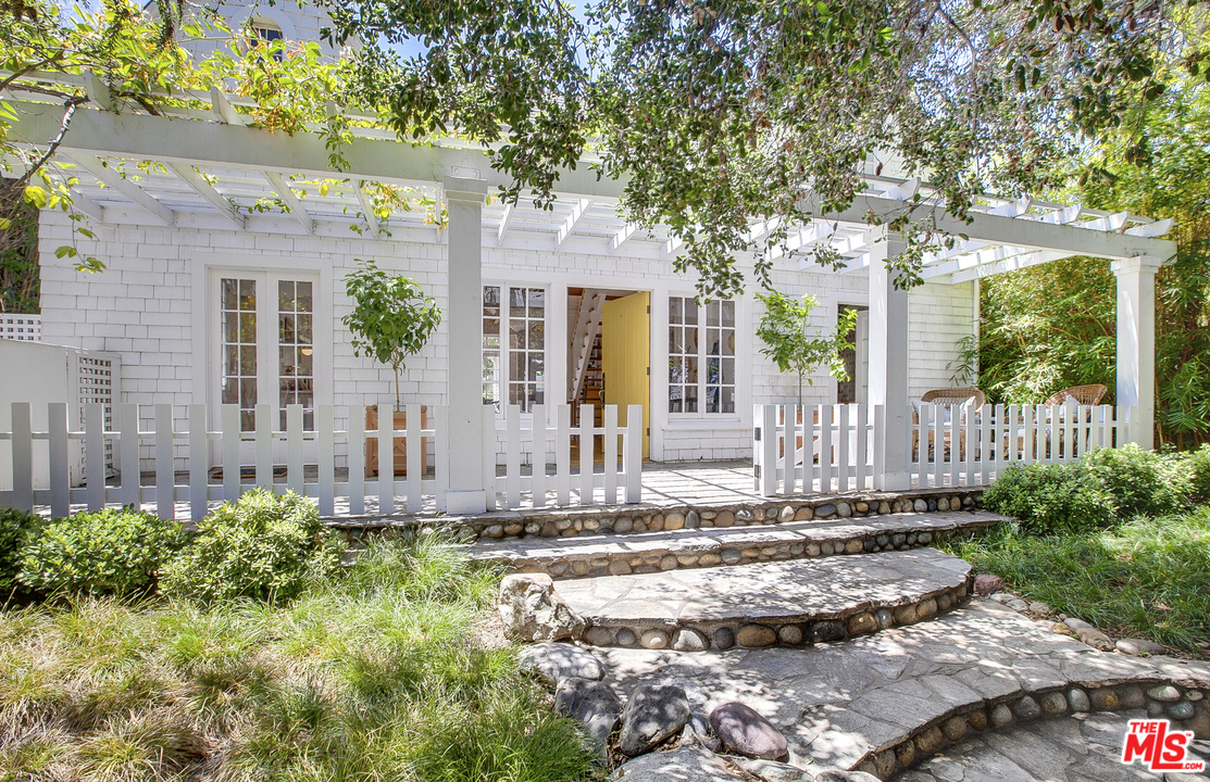 a front view of a house with a garden and plants