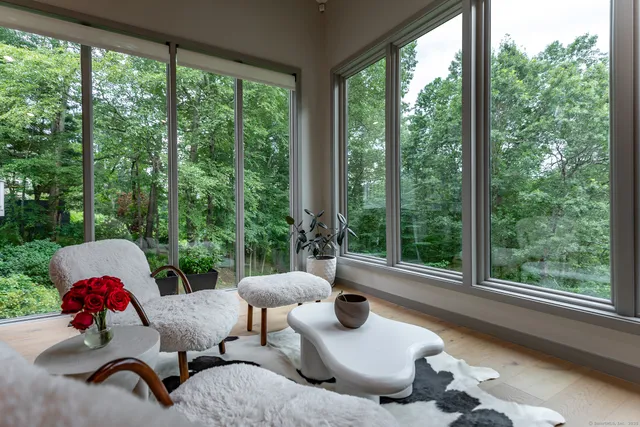 a living room with furniture and a floor to ceiling window
