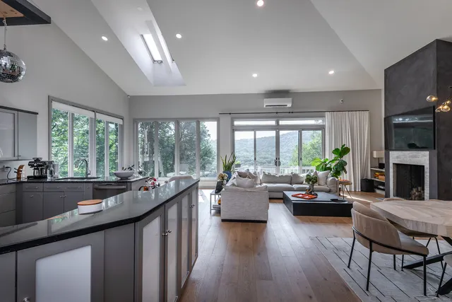 a living room with furniture fireplace and large windows