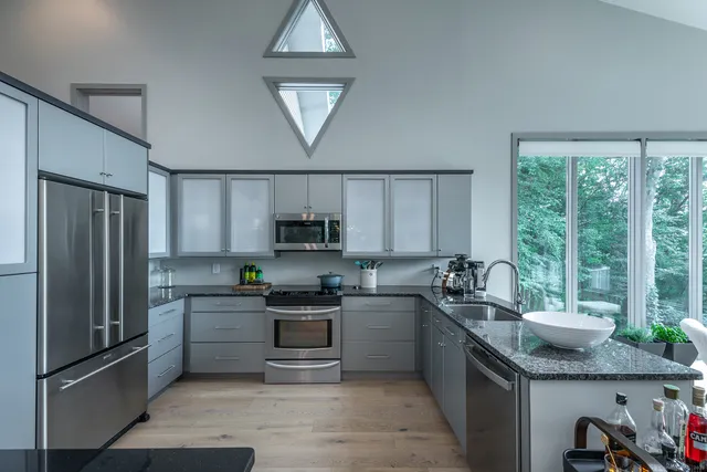 a kitchen with stainless steel appliances granite countertop a sink stove and refrigerator