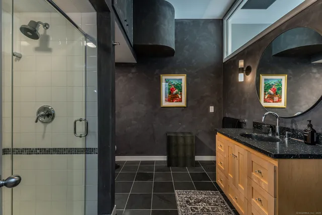 a bathroom with a granite countertop sink a toilet and shower