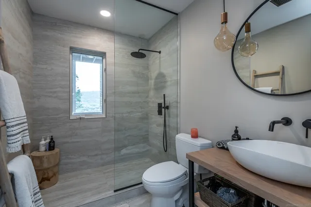 a bathroom with a granite countertop toilet sink and mirror