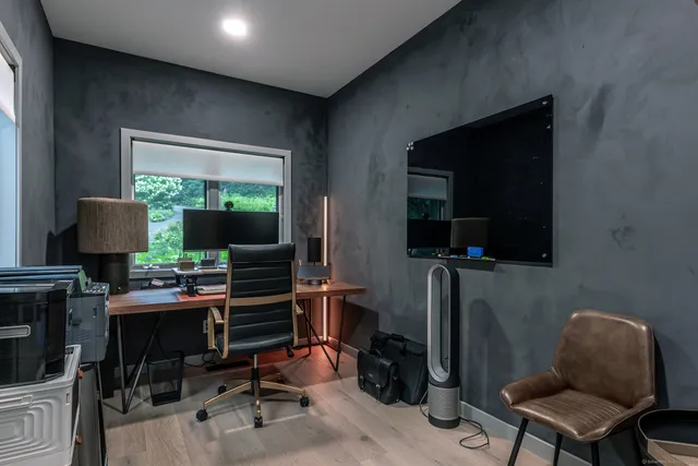 a view of a workspace with furniture and a window