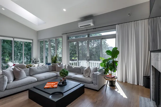 a living room with furniture potted plant and a large window