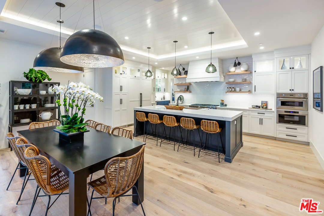 24277 Dry Canyon Cold Creek Road Calabasas, CA 91302 - Photo 9 of 45 a living room with stainless steel appliances kitchen island a table and chairs in it