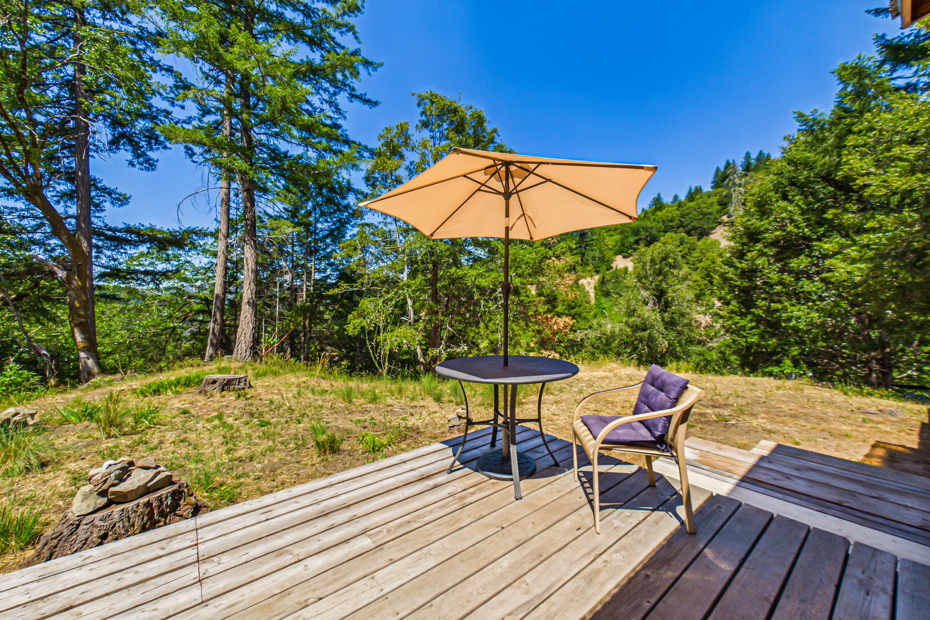 60890 Bell Springs Road Laytonville, CA 95454 - Photo 15 of 77 a view of a backyard with a table and chairs under an umbrella
