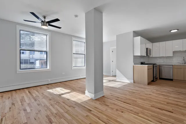 a view of a kitchen with wooden floor and a ceiling fan