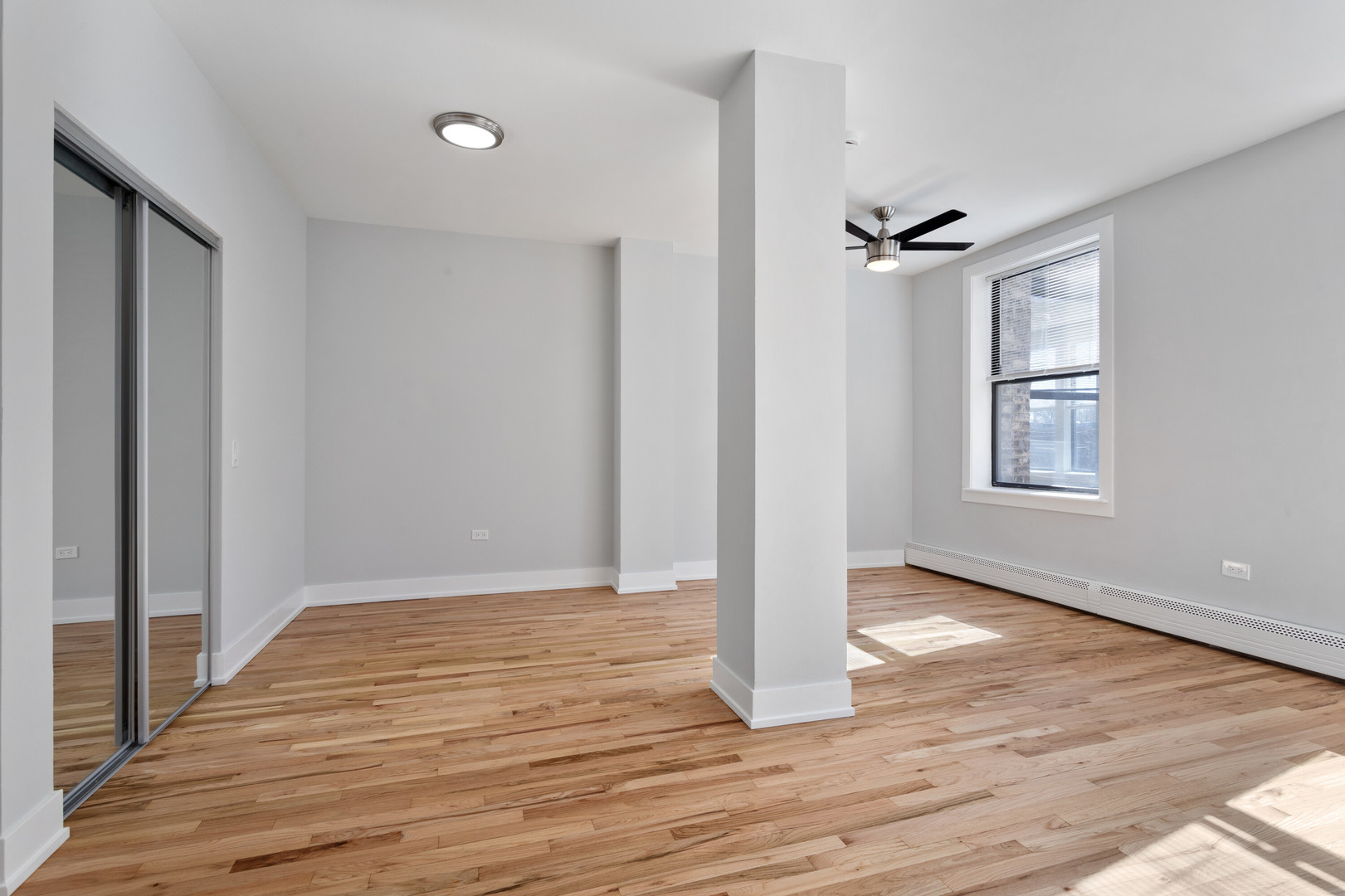 1625 West Howard Street, Unit 216 Chicago, IL 60626 - Photo 6 of 9 a view of an empty room with wooden floor and a window