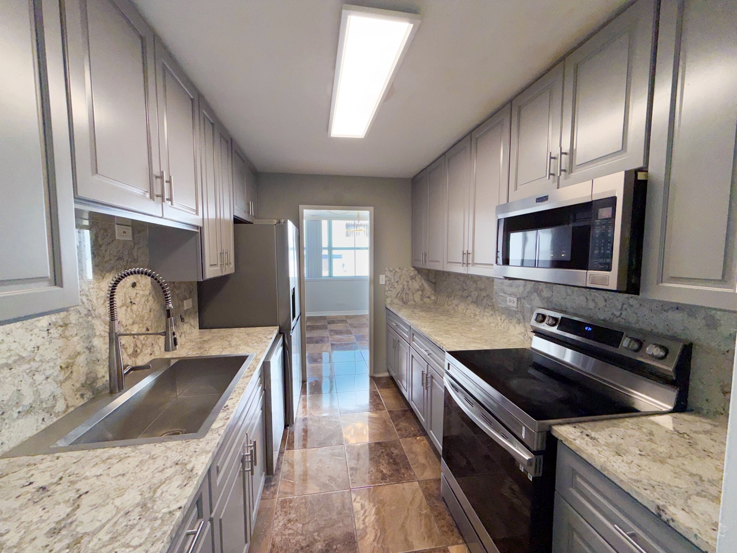 6301 North Sheridan Road, Unit 24E Chicago, IL 60660 - Photo 10 of 52 a kitchen with granite countertop stainless steel appliances and wooden cabinets