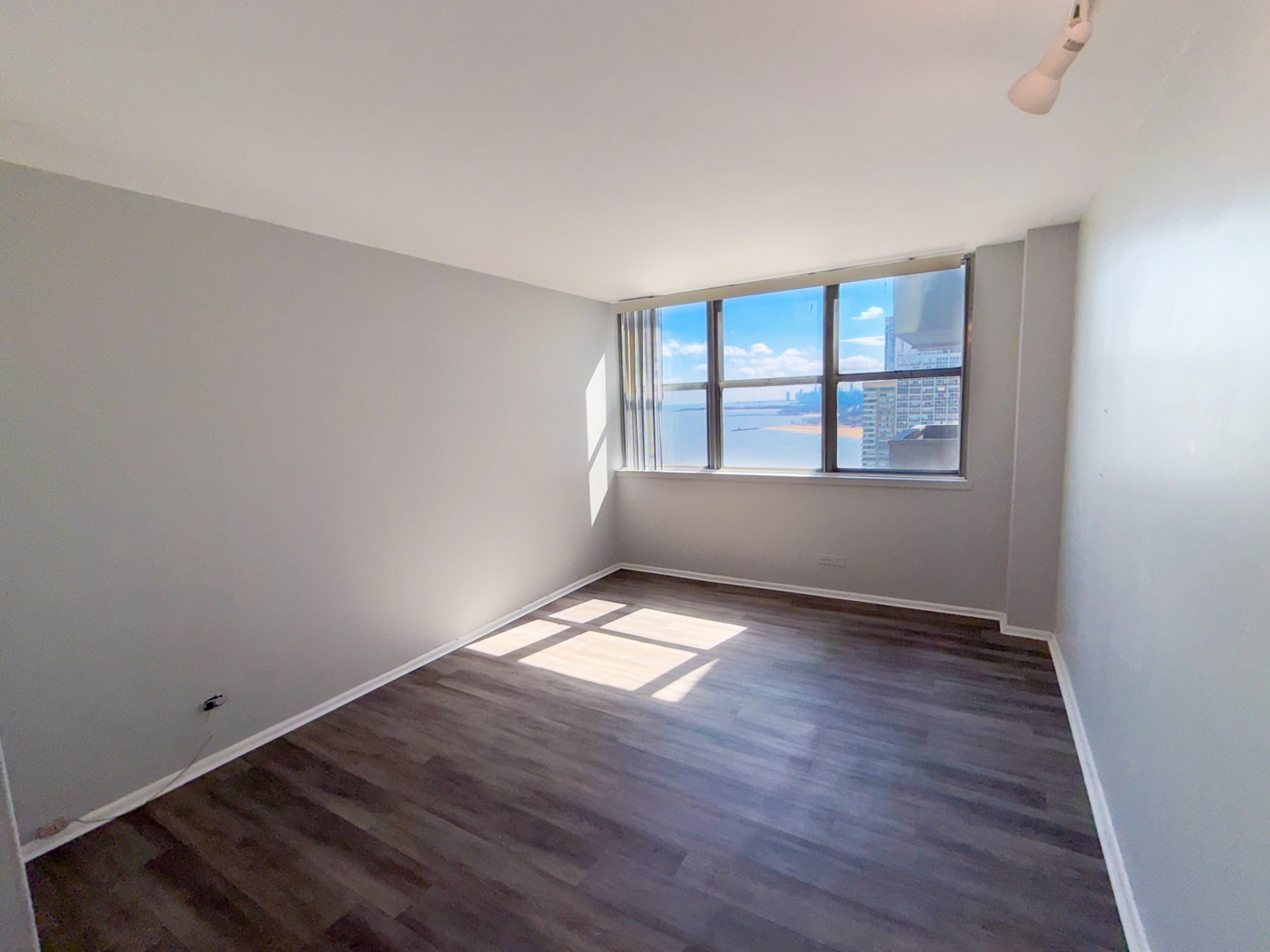 6301 North Sheridan Road, Unit 24E Chicago, IL 60660 - Photo 17 of 52 an empty room with wooden floor and windows