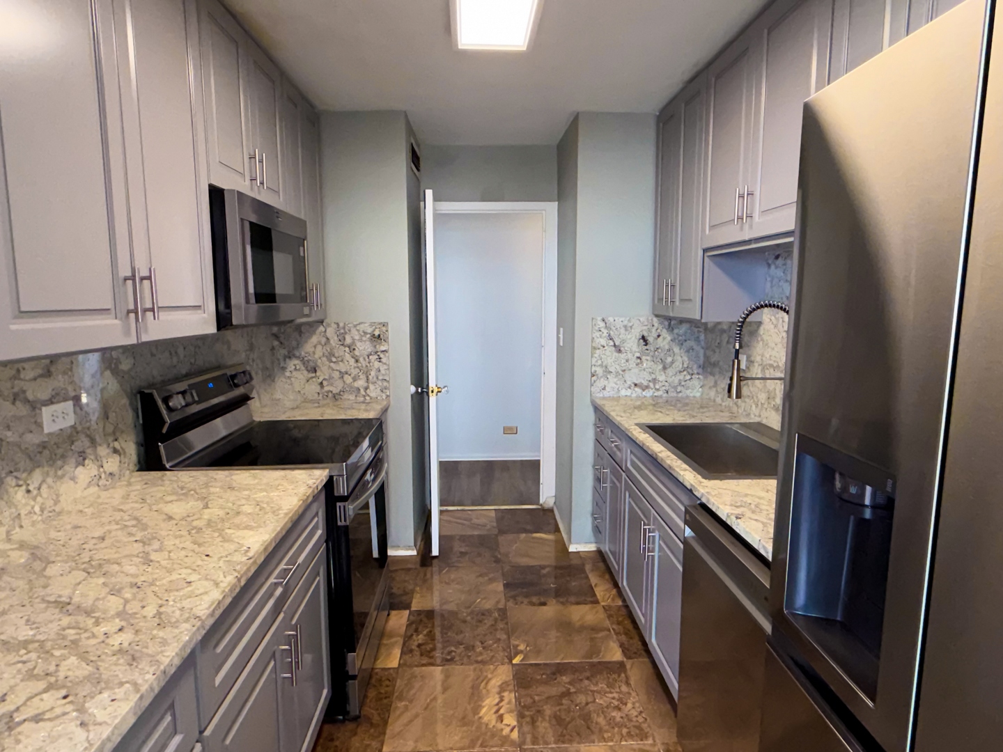 6301 North Sheridan Road, Unit 24E Chicago, IL 60660 - Photo 7 of 52 a kitchen with stainless steel appliances granite countertop a refrigerator a stove and a sink