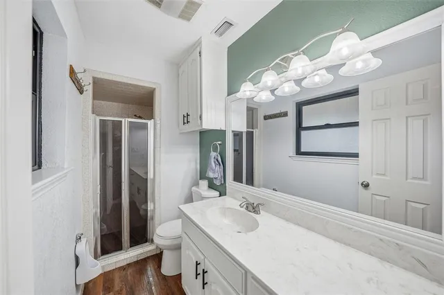 a bathroom with a sink vanity mirror and toilet