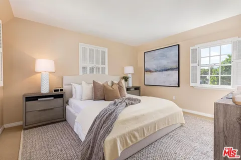 a bedroom with a bed and a lamp on dresser