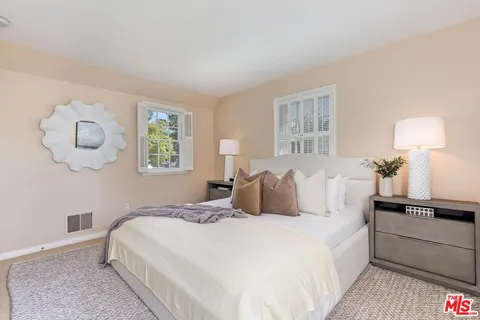 a bedroom with a bed and painting on the wall