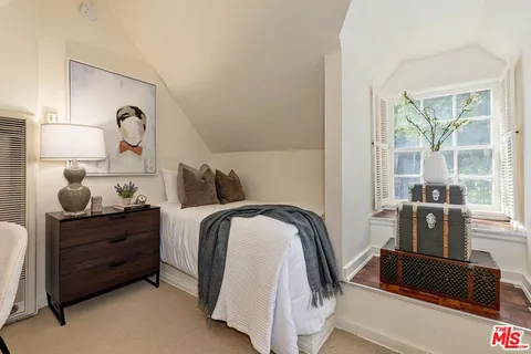 a bedroom with a bed and dresser with mirror