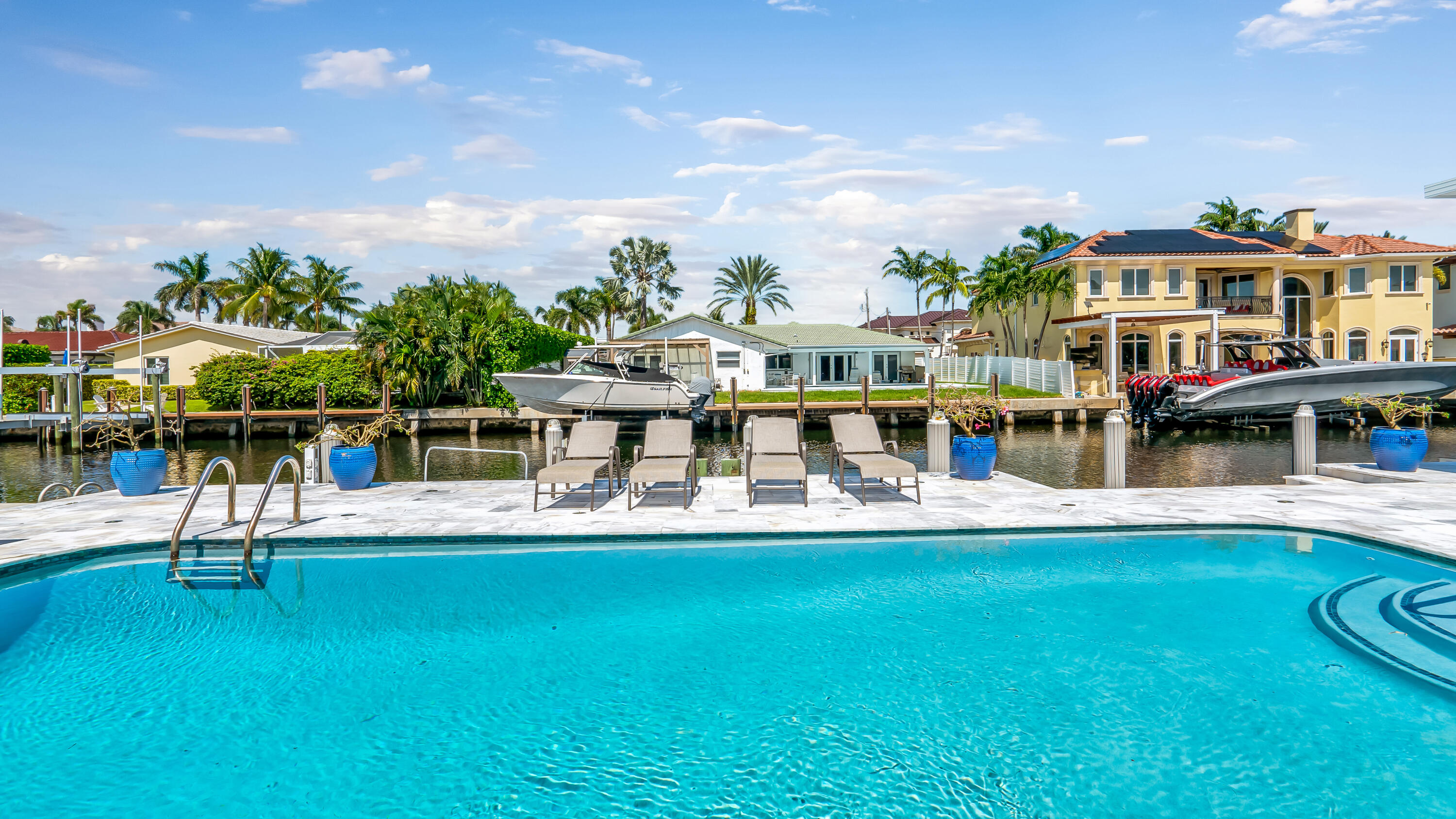 831 Dover Street Boca Raton, FL 33487 - Photo 71 of 71 a view of a swimming pool with lawn chairs and plants