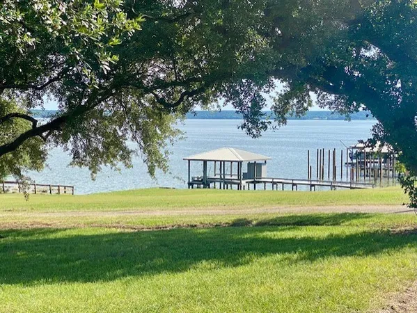 a view of swimming pool with big yard and large trees