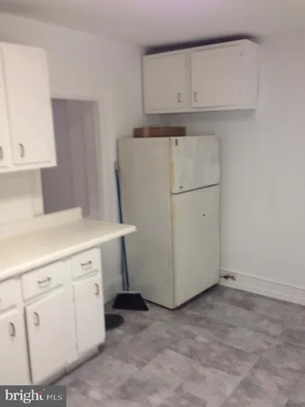 a kitchen with white cabinets and white appliances