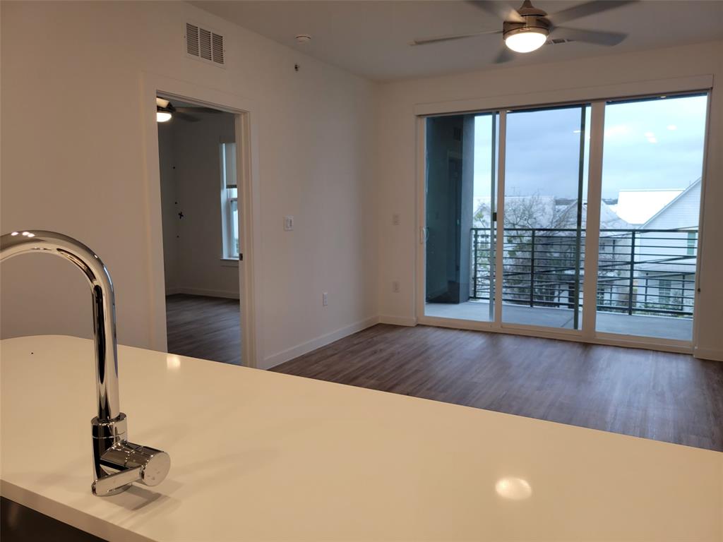 4801 Springdale Road, Unit 2211 Austin, TX 78723 - Photo 18 of 19 A well-lit open floorplan reveals a private balcony with city views, ideal for modern living.