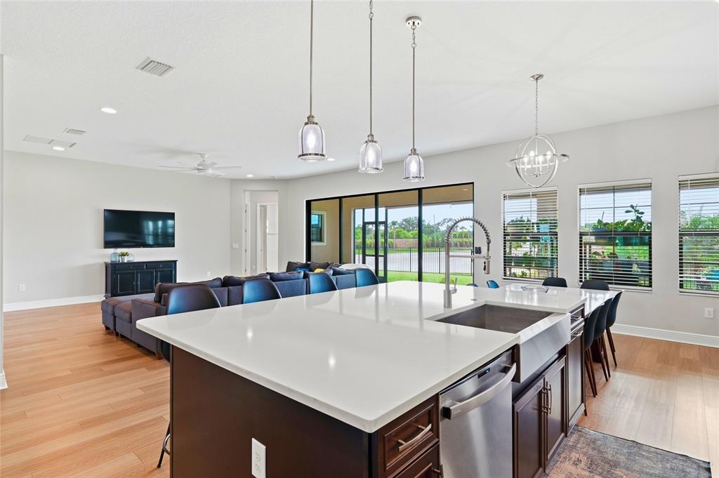 8207 Rushton Place Parrish, FL 34219 - Photo 11 of 65 a large kitchen with kitchen island a large counter space windows and appliances
