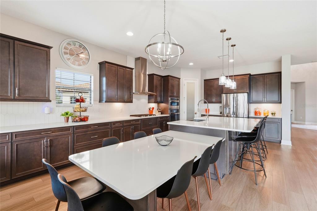 8207 Rushton Place Parrish, FL 34219 - Photo 12 of 65 a kitchen with a dining table chairs sink and stove