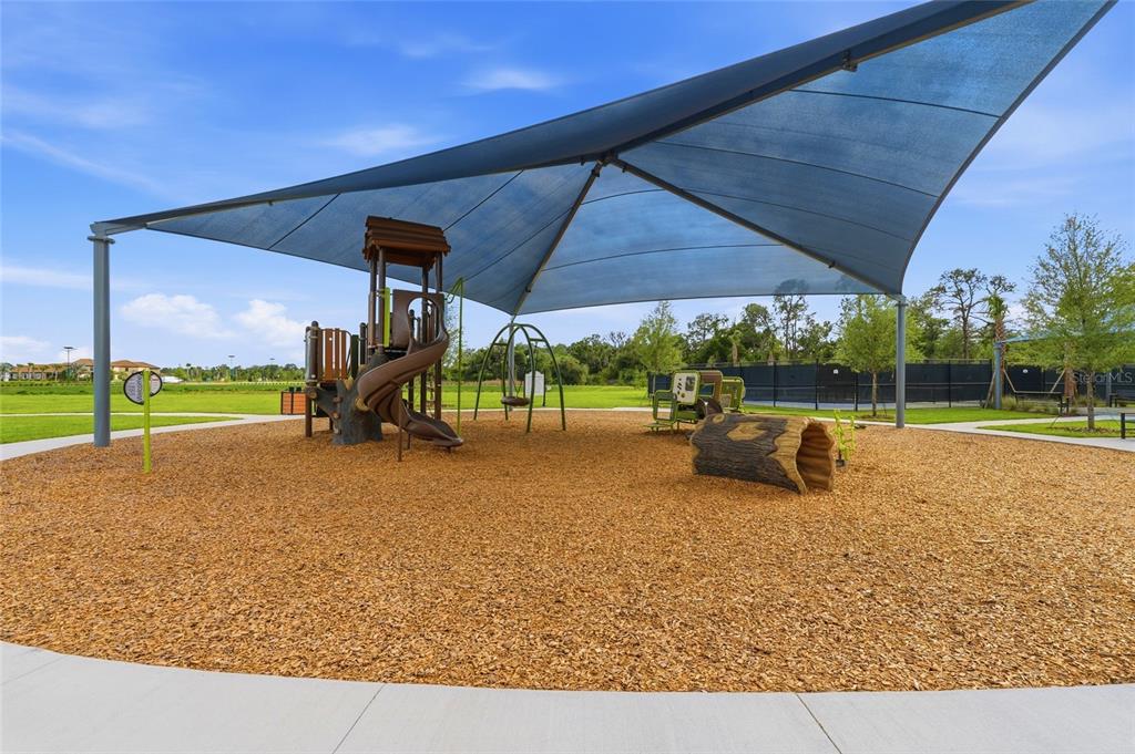 8207 Rushton Place Parrish, FL 34219 - Photo 65 of 65 a view of a big yard with table and chairs under an umbrella
