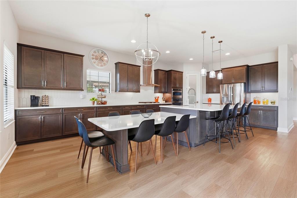 8207 Rushton Place Parrish, FL 34219 - Photo 7 of 65 a kitchen with a dining table chairs sink and cabinets