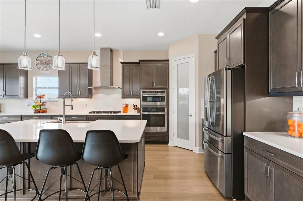 8207 Rushton Place Parrish, FL 34219 - Photo 8 of 65 a kitchen with stainless steel appliances granite countertop a refrigerator a sink a stove a dining table and chairs