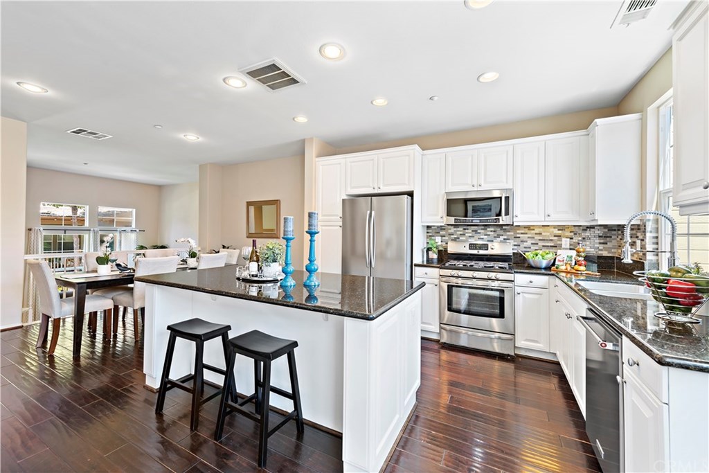 Feel inspired to prepare delicious meals amongst the granite countertops, large center island, stainless steel appliances, beautiful backsplash, white cabinetry & large cheery window.