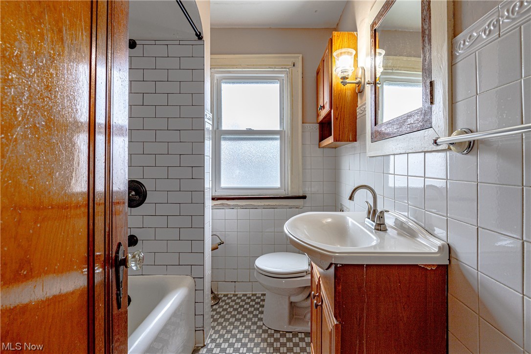 3337 Ralph Avenue Cleveland, OH 44109 - Photo 23 of 30 Full bathroom with toilet, tile walls, oversized vanity, tile flooring, and bathtub / shower combination