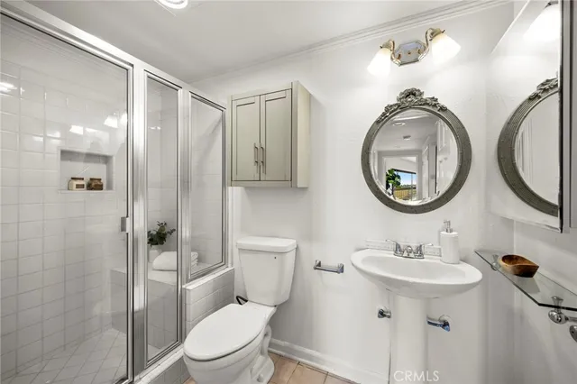 a bathroom with a sink a mirror a toilet and a shower