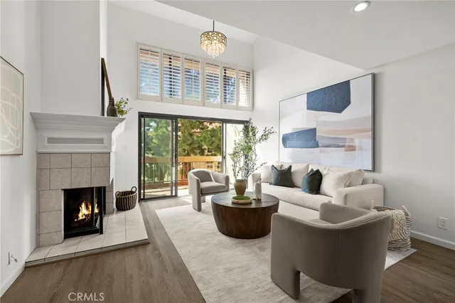 a living room with furniture a fireplace and a floor to ceiling window