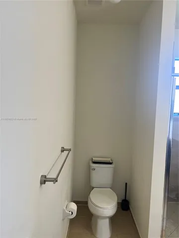 a living room with furniture a flat screen tv and kitchen view