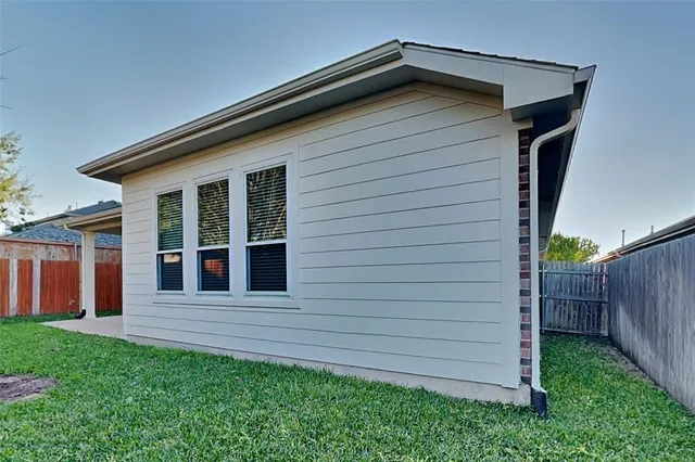 an empty room with ceiling fan and window