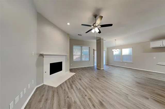 a view of empty room with wooden floor and fireplace
